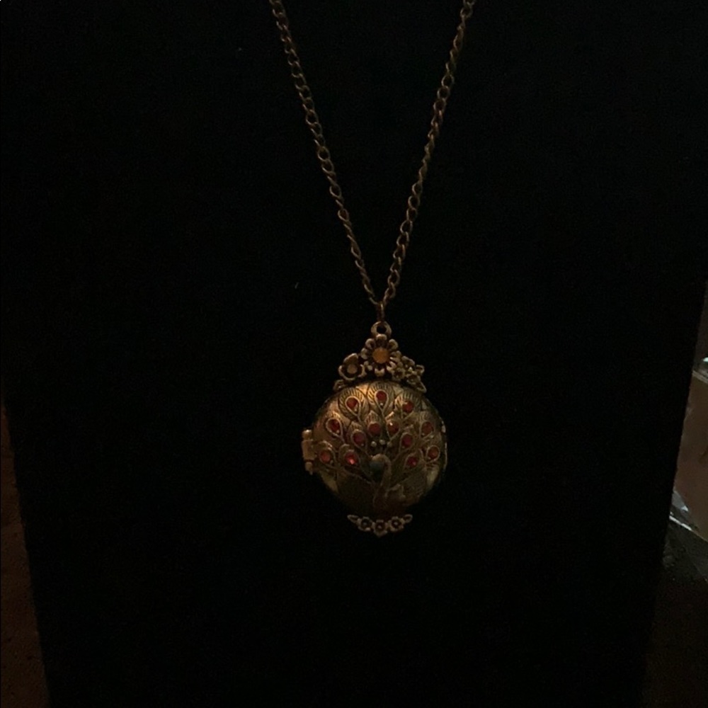 Peacock locket with ornate red stone inlays